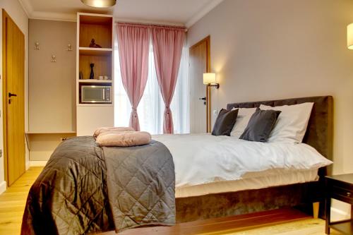 - une chambre avec un grand lit et une fenêtre dans l'établissement Apartament TANGO la casa PIANO HOUSE ,cu parcare, à Alba Iulia