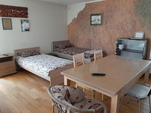 Cette chambre comprend une table, une table et des chaises. dans l'établissement Apartamentai Luna, à Panevėžys