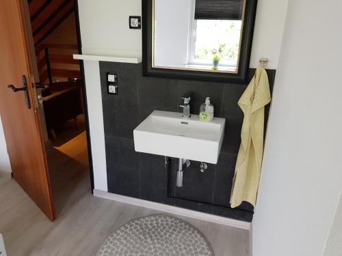 a bathroom with a white sink and a mirror at Best Pension in Glückstadt