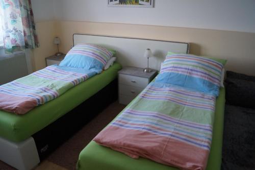 a bedroom with two beds and a night stand at Ferienwohnung Höbart in Dorfstetten