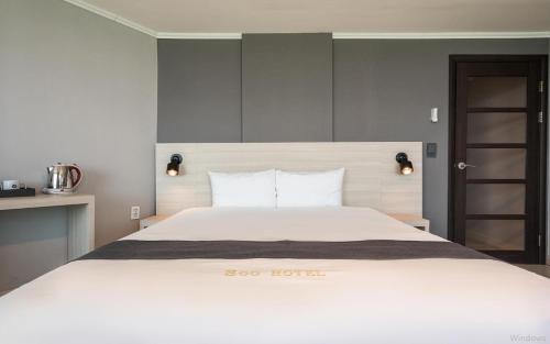 a bedroom with a large white bed with white pillows at Gyeongpo Soo Hotel in Gangneung