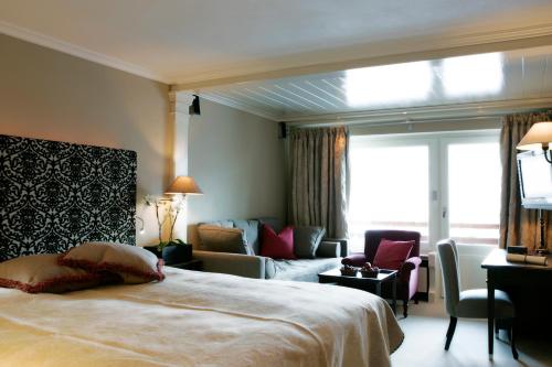 a hotel room with a bed and a living room at Hotel Berghof in Lech am Arlberg