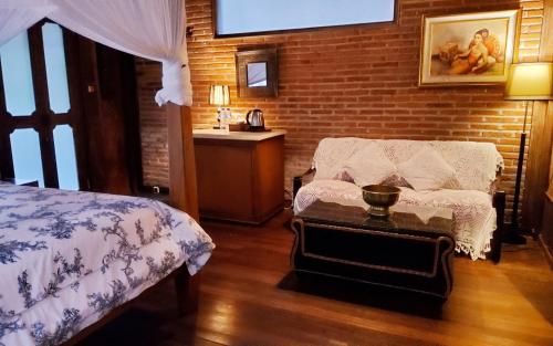 a bedroom with a bed and a chair and a sink at Mi Casa - The gem of Ijen in Banyuwangi