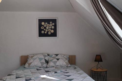 a bedroom with a bed and a picture on the wall at Duplex au centre ville, dans cour intérieure calme in Dole