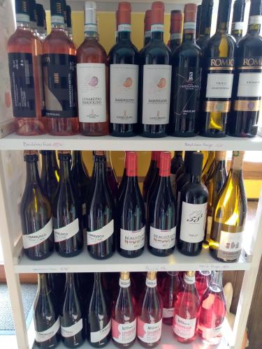 une étagère remplie de nombreuses bouteilles de vin dans l'établissement Jonquille Chic La Piccola Venezia, à Vrécourt
