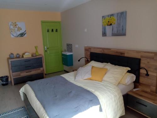 - une chambre avec un grand lit et une porte verte dans l'établissement Jonquille Chic La Piccola Venezia, à Vrécourt