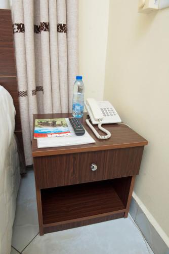 a table with a phone and a book on it at Airport Transit Lodges in Dar es Salaam