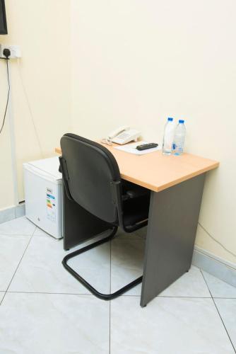 a desk with a chair and two water bottles on it at Airport Transit Lodges in Dar es Salaam