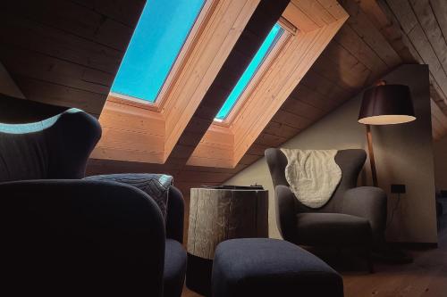 a living room with two chairs and a window at Hiša Križaj in Bohinj