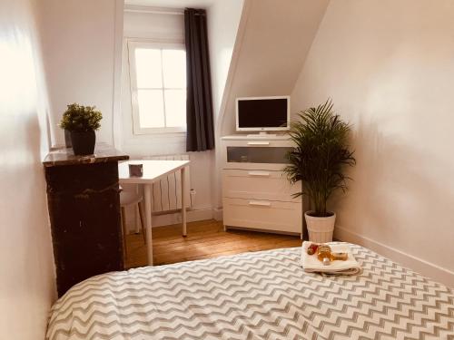 une petite chambre avec un lit et une télévision dans l'établissement APPARTEMENT 4/6p Haut Standing / Centre ville CAEN, à Caen
