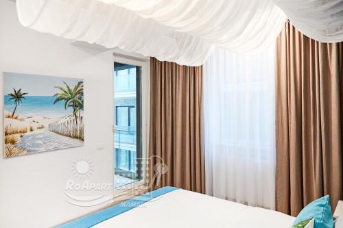 a bedroom with a bed and a window at RoApart -Sea VIEW Apartamente 2 camere la 1 min de plaja in Mamaia Nord