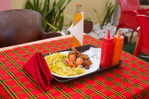 un plato de comida en una mesa con un plato de pasta en Airport Transit Lodges, en Dar es Salaam