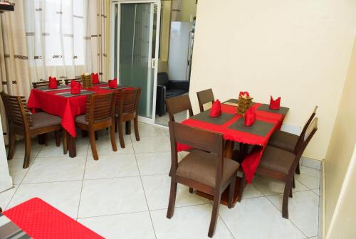 a dining room with a red table and chairs at Airport Transit Lodges in Dar es Salaam