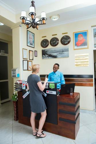 a woman standing at a cash register in a store at Airport Transit Lodges in Dar es Salaam