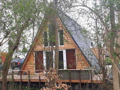 a small house with a pyramid shaped roof at A-frame volledig vrijstaande woning in Hensbroek