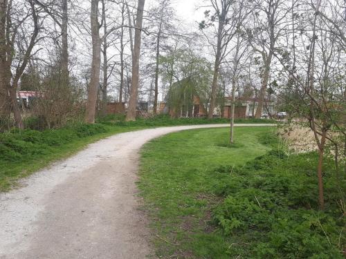 a dirt road in the middle of a field at A-frame volledig vrijstaande woning in Hensbroek