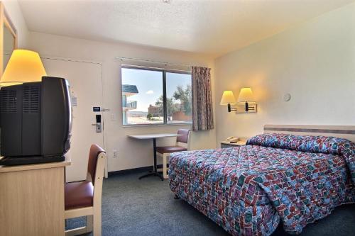 a hotel room with a bed and a television at Motel 6-Grants, NM in Grants