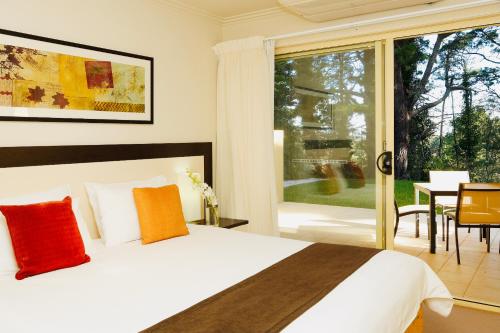 a bedroom with a bed and a large window at Falls Mountain Retreat Blue Mountains in Wentworth Falls