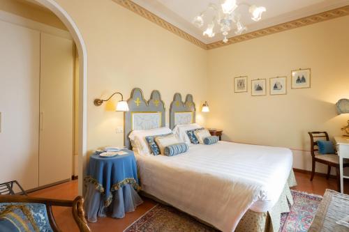 a bedroom with a bed with blue and white pillows at Hotel Villa Marsili in Cortona