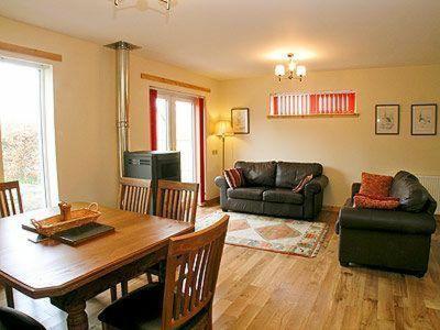 een woonkamer met een houten tafel en een bank bij Tulach Ard in Grantown on Spey