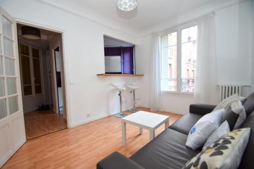 ein Wohnzimmer mit einem Sofa und einem Tisch in der Unterkunft Top location near ParisSuperb cosy 2p apartment in Vincennes