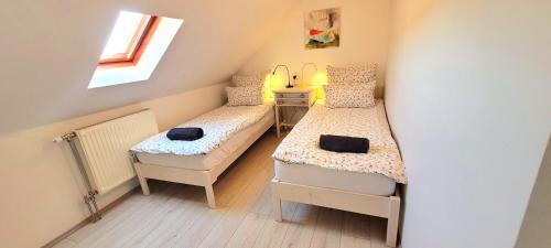 a small room with two beds and a window at Napkert Apartman in Noszvaj