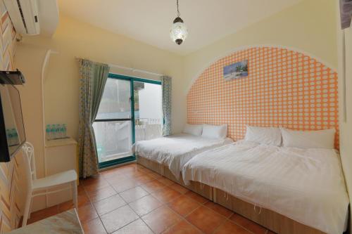 a bedroom with a bed with an orange wall at Rainbow B&B in Dahan