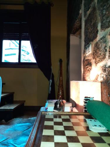 um quarto com um piso xadrez e uma janela em Casa Rural Cabo de Aráns em Oroso