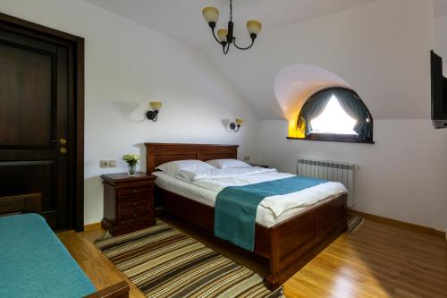 Un dormitorio con una cama grande y una ventana en Pensiunea Tara Fagilor, en Suceava