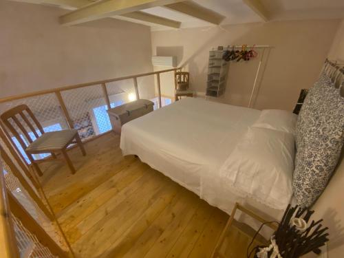 una camera con letto bianco e pavimento in legno di Casa Garito Teresa a Lampedusa