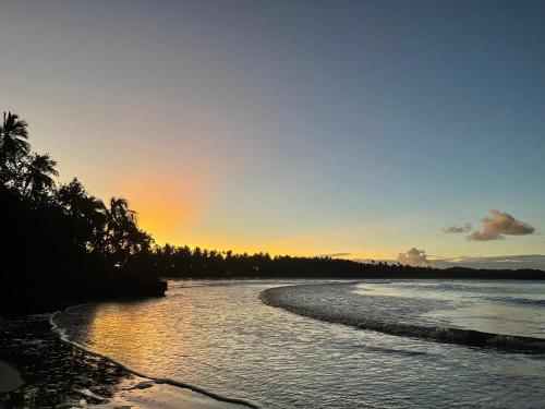 a beach with a sunset in the background at Pousada Horizonte Azul in Ilha de Boipeba