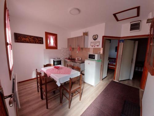 a kitchen and dining room with a table and chairs at Kuća Talija in Kalna