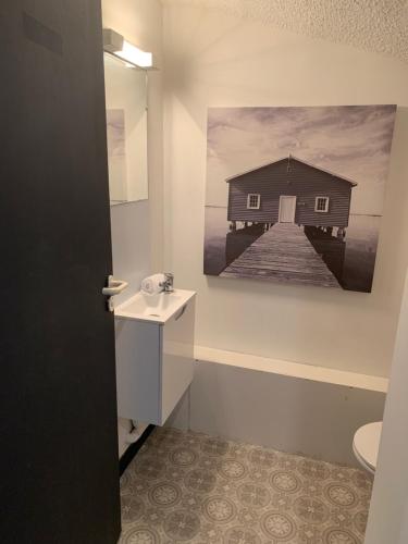 a bathroom with a picture of a building on the wall at Appartement LE TRITON in Perros-Guirec