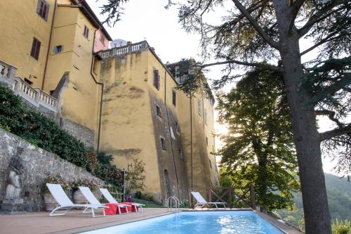 a swimming pool in front of a building with lounge chairs at Il Castello di San Michele in San Michele in Teverina