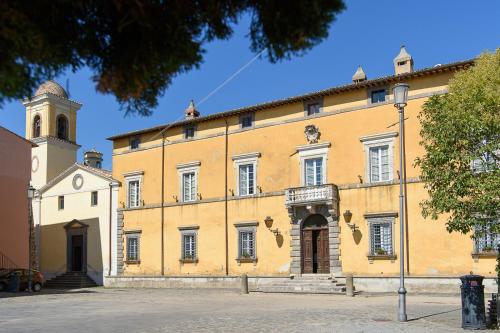 a large yellow building with a clock tower at Il Castello di San Michele in San Michele in Teverina