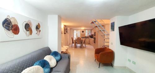een woonkamer met een bank en een flatscreen-tv bij Pieno Centro Apartment in Tropea