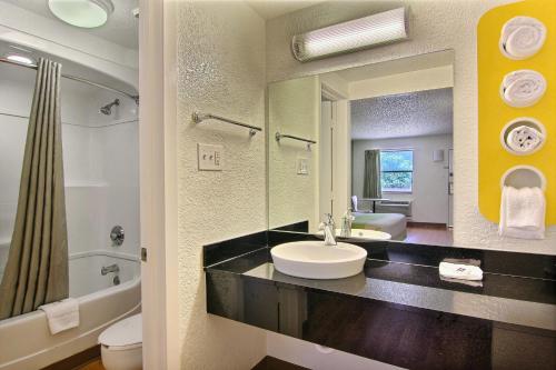 a bathroom with a sink and a large mirror at Motel 6 Austin, TX - Central Downtown UT in Austin