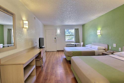 a hotel room with two beds and a desk at Motel 6 Austin, TX - Central Downtown UT in Austin
