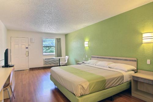 a bedroom with a bed and a desk and a television at Motel 6 Austin, TX - Central Downtown UT in Austin