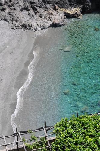 a beach with a fence next to the water at Residence Due Torri in Maiori