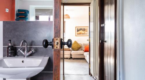 Kasbah cosy cottage Kendal في كندال: حمام مع حوض ومغسلة بيضاء