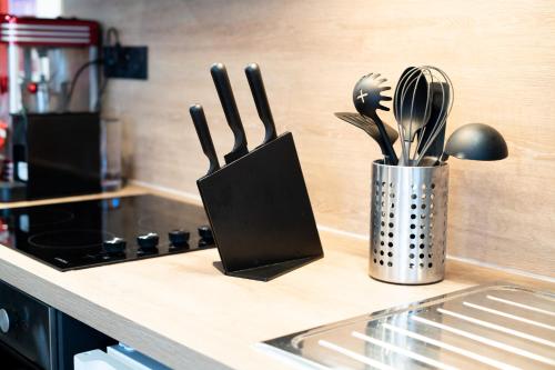 un comptoir de cuisine avec un conteneur d'ustensiles de cuisine dans l'établissement Capsule Cinéma - Balneo home cinema playstation 5, à Valenciennes