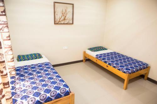 a bed room with two beds and a desk at Lusaka Backpackers in Lusaka