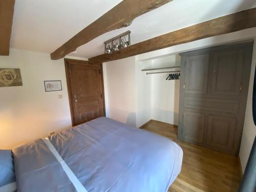 a bedroom with a bed and a wooden door at Le Héron - Gîte de charme clôturé, accès à la rivière - 6 ou 10 personnes in Fauvillers