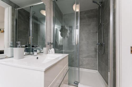 a bathroom with a white sink and a shower at The White House - Grand & Spectacular 5-bed, sleeps 14- Central Solihull, NEC, JLR, HS2, Resorts World, Airport in Solihull