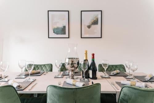 a table with wine bottles and wine glasses on it at The White House - Grand & Spectacular 5-bed, sleeps 14- Central Solihull, NEC, JLR, HS2, Resorts World, Airport in Solihull