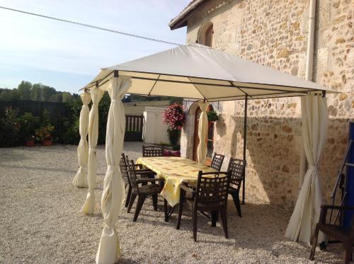 a tent with a table and chairs under it at La Grange bnb in Yviers