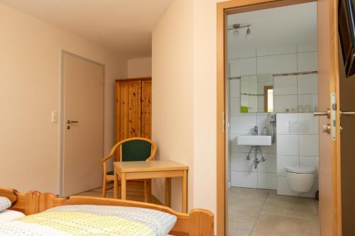 a bedroom with a bed and a desk and a bathroom at Landgasthof Zum Wolfsberg in Dietfurt