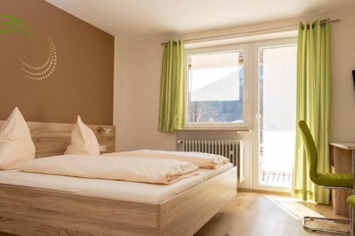 a bedroom with a bed with green curtains and a window at Landgasthof Zum Wolfsberg in Dietfurt