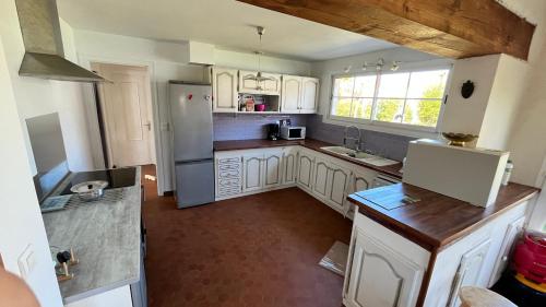 - une vue de tête sur une cuisine équipée d'appareils blancs dans l'établissement Maison 130 M2 6 pers proche lac, à Soustons